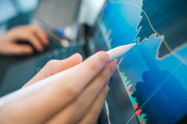 istock A person makes adjustments to financial reports, illustrating the proactive approach needed to manage early investments for a secure financial future. 2190014164
