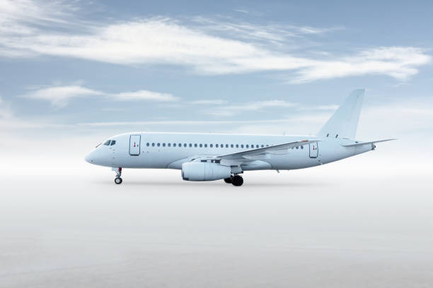 istock White passenger plane isolated on bright background with sky 2190014835