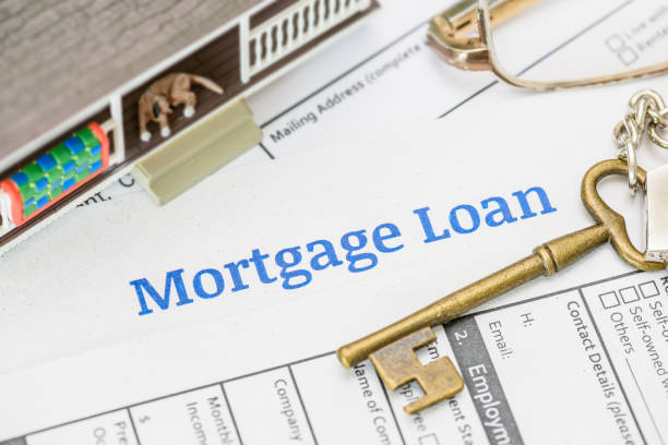 istock Mortgage loan concept: Securing your dream home. A house model, a key (representing ownership and security), and a mortgage document, highlighting the financial and emotional aspects of buying a home. 2190017770