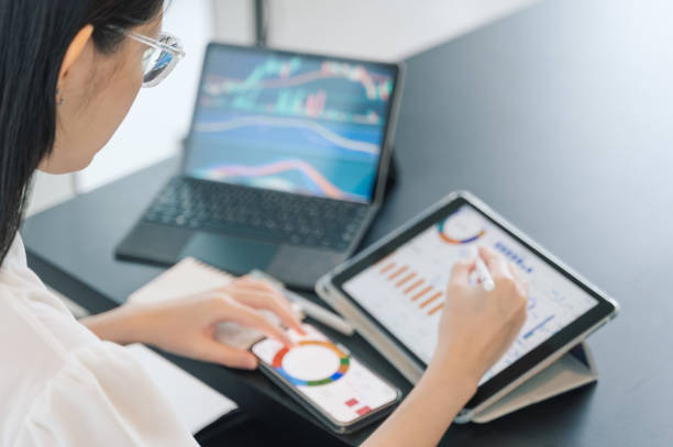 istock A person compares financial data on a tablet and phone, symbolizing the careful steps involved in early investment decisions to ensure long-term financial security. 2190019262