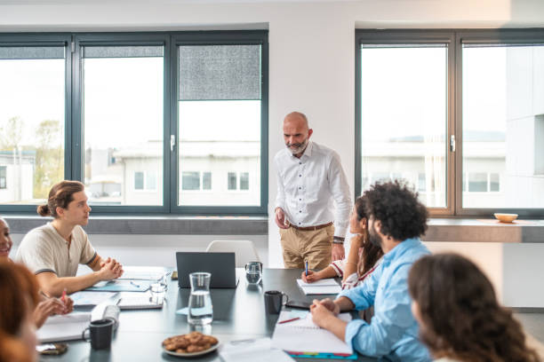 istock Confident Caucasian Male Leading Engaged Meeting with Diverse Team 2190019743