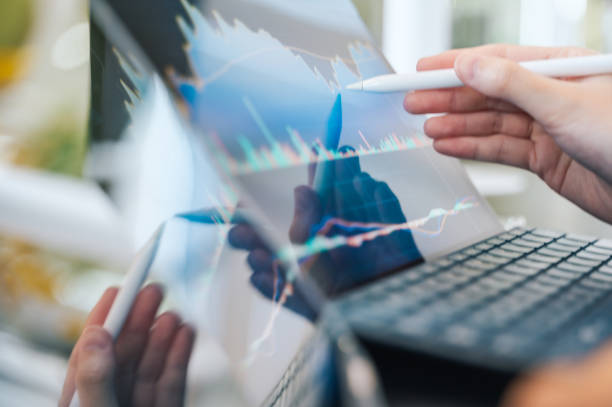istock A person makes adjustments to financial reports, illustrating the proactive approach needed to manage early investments for a secure financial future. 2190019966