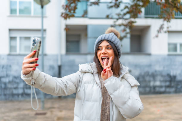 istock Woman gesturing success while taking selfie in the city 2190023763