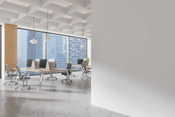 istock Empty wall mockup in modern office space with desks and computers in the background. 3D Rendering 2190024784