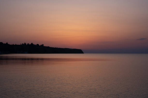 Beautiful orange-pink early summer sunset over the sea in Greek shore