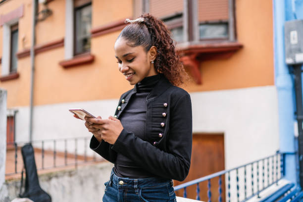 istock Young latin woman using mobile phone in the city 2190033459