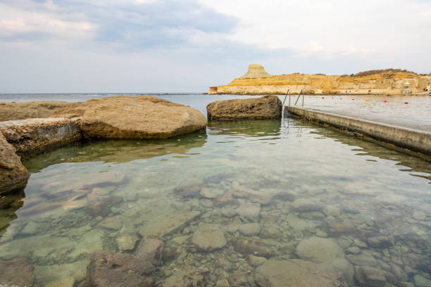 A prominent geological feature formed from soft globigerina limestone, this pale, rounded hillock is a remnant of ancient marine sediments that have been shaped by erosion over millennia. Situated near the traditional salt pans of Xwejni Bay, it provides a striking contrast to the surrounding coastline and offers a glimpse into the island's natural history.