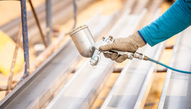 istock Construction worker painting metal structure surface coating with a spray gun at construction site. Metal corrosion and rust protection. Industrial precision. Protective coating to a metal structure. 2190037431