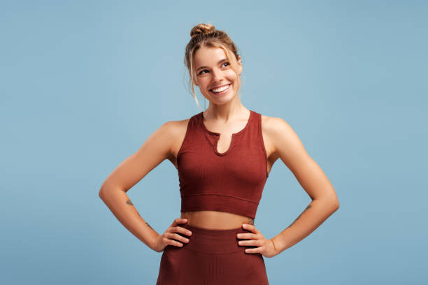 istock Happy fit woman posing in studio, looking to side, isolated on blue background 2190040489