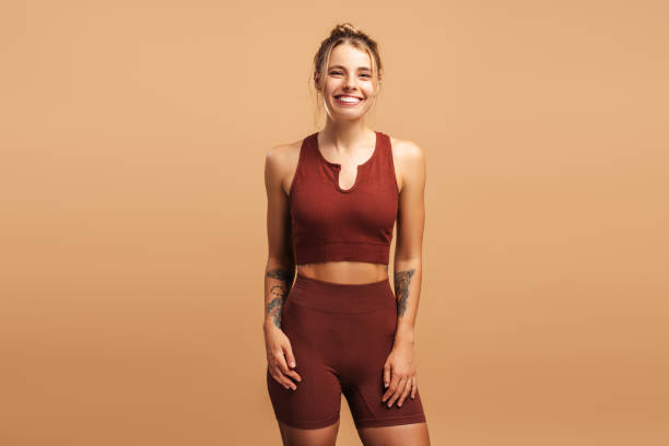 istock Smiling pretty young female coach looking at camera, isolated on beige background 2190040545