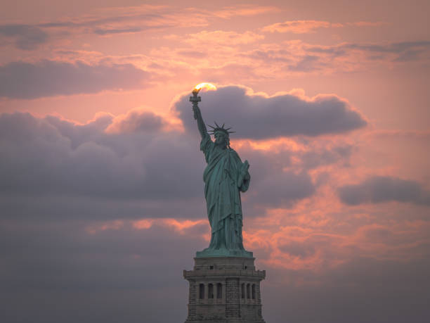 Perfection matching sun and Statue of Liberty during sunset