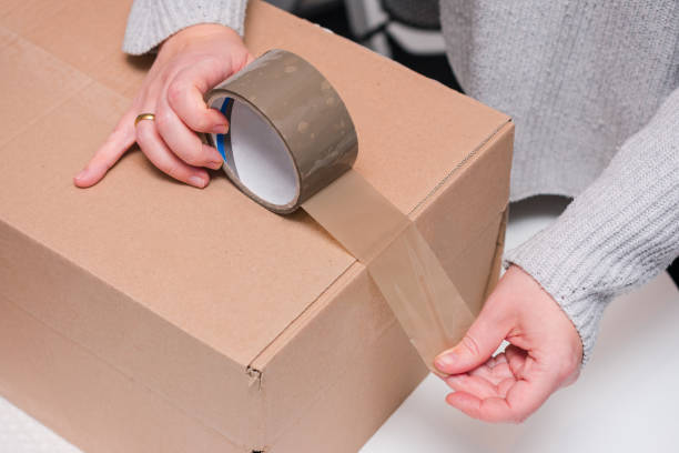 istock Person is wrapping a box with tape 2190056373
