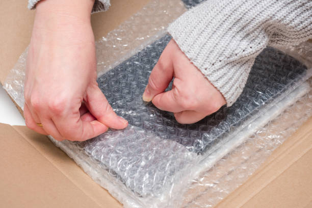 istock Person tapes on bubble pack. Prepares the package for shipment. 2190056644