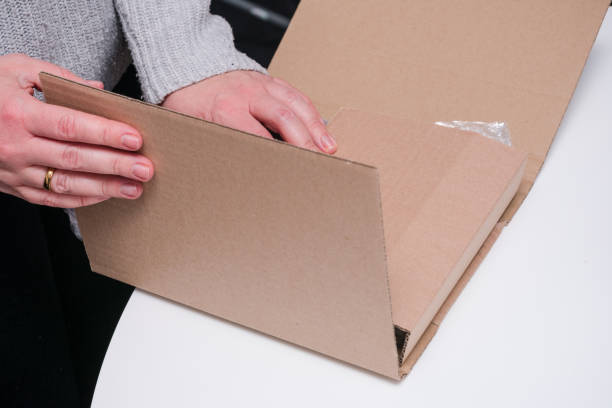 istock Person is closing a cardboard box that contains a object to shipping 2190057196