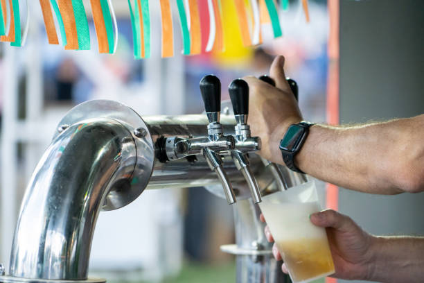 Bartender serving beer. Person filling a glass of alcohol stock photo