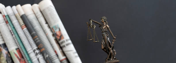 lady justice statue with newspaper