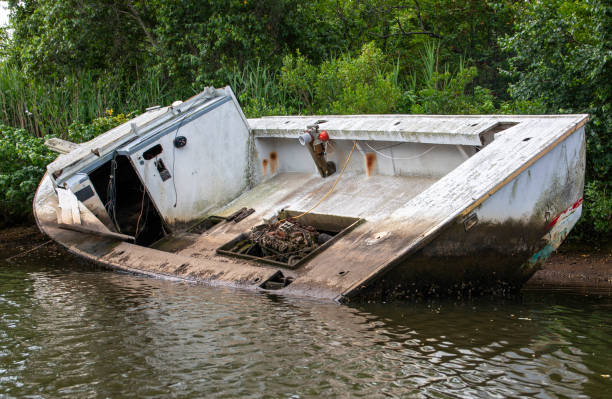 istock Abandoned Boat Rests Partially Submerged in Calm Waters Surrounded by Lush Vegetation 2190069410