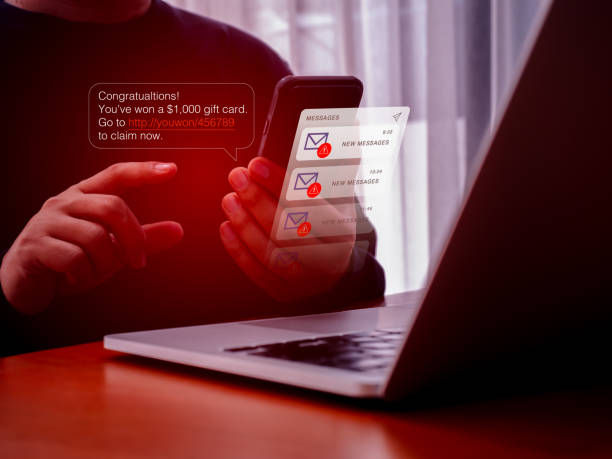istock SMS spam, fake text message phishing scammer concept. Winning congratulations phishing, text with link tracking, on message alert display on mobile phone screen in hand, messages from unknown number. 2190070572
