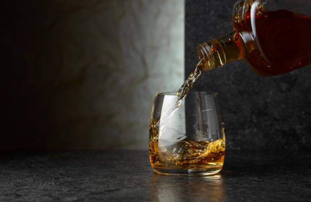 istock Pouring whiskey from a bottle into a glass. 2190074533