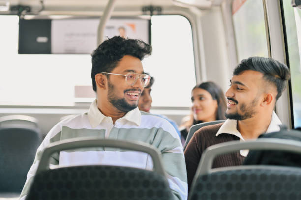 istock University students engaged in a conversation while travelling in a bus 2190075023