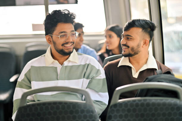 istock University students engaged in a conversation while travelling in a bus 2190075024