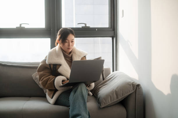 istock asian female using laptop on chair 2190076957