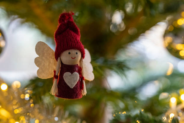 istock A red and white angel ornament hangs on a Christmas tree 2190077402