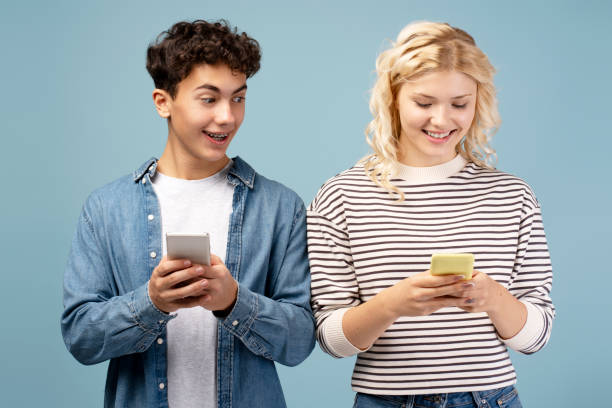istock Positive, attractive couple, boyfriend and girlfriend using smartphone, text message together 2190080024