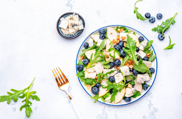 istock Salad with pear, blueberries, blue cheese, arugula and walnuts. White background, top view 2190081827