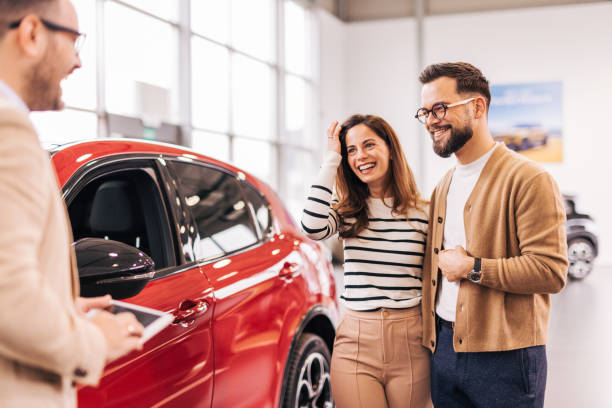istock Car salesman discussing contract with couple 2190082873