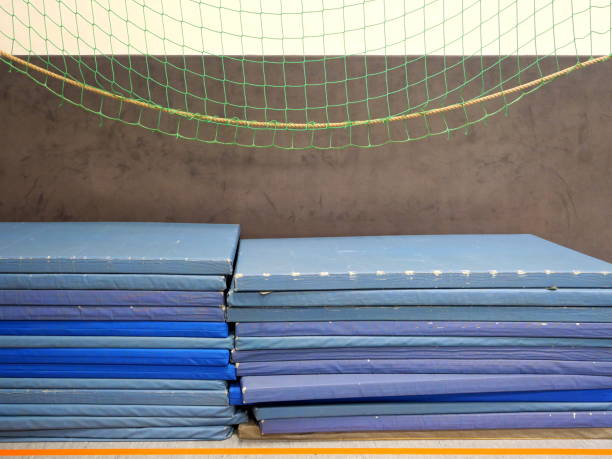 istock Stacked, heavily worn gym mats 2190085557