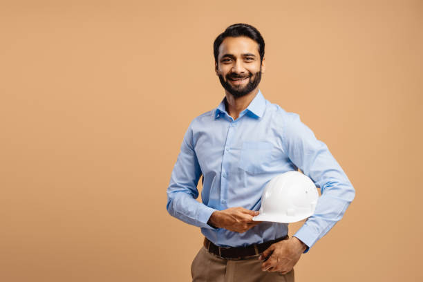 istock Smiling, confident, attractive Middle aged man, engineer holding white hard hat, looking at camera 2190087273