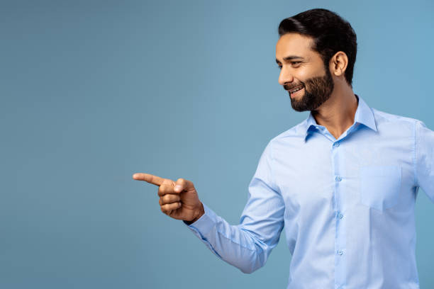istock Smiling, happy, bearded middle aged Indian man pointing finger on copy space 2190087344