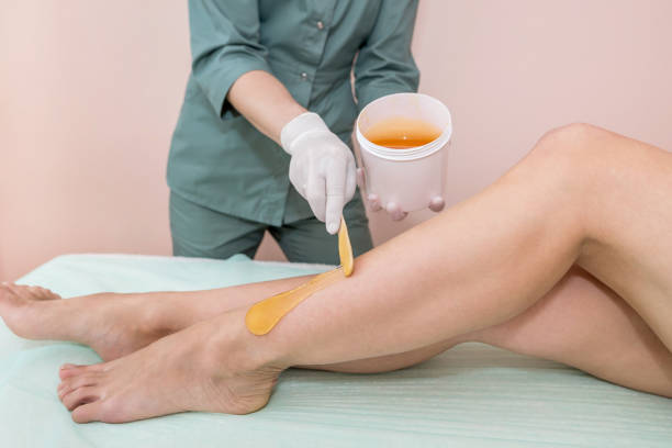 istock the process of epilation of the legs by the method of shugaring, using glucose paste.Cosmetological sugar hair removal of female legs in a spa center 2190089928
