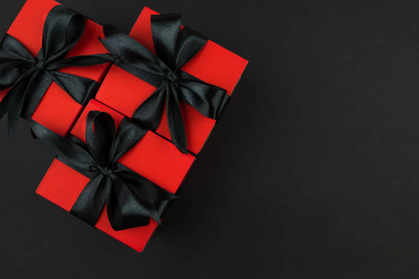 istock Top view photo of red gift boxes with black bow on isolated black background with copy space. 2190090136