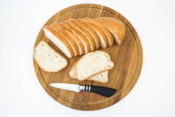 sliced bread and a knife on a white background. White bread slices. Baton on a white background.