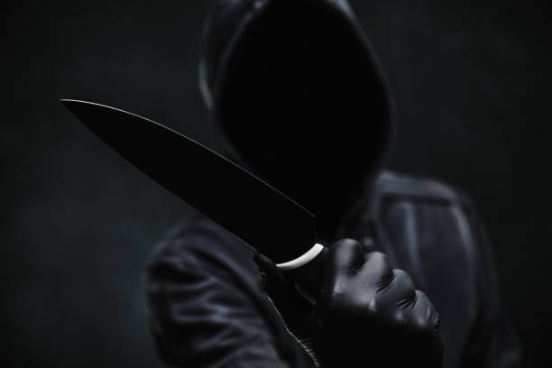 istock Sinister hooded criminal with sharp knife weapon 2190095299
