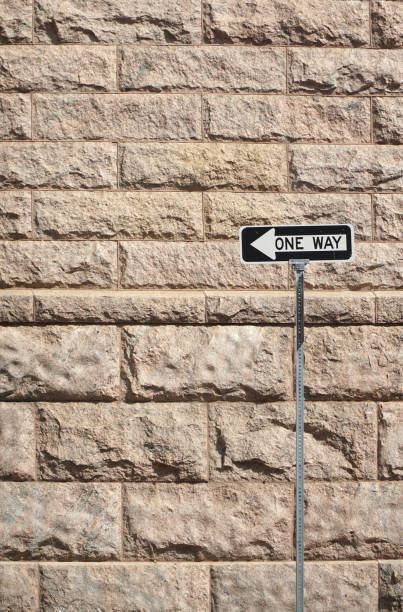 istock one way sign in front of the brick wall background 2190095921