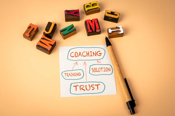 istock Coaching Concept. Notepad and wooden alphabet letters on a light background 2190097332