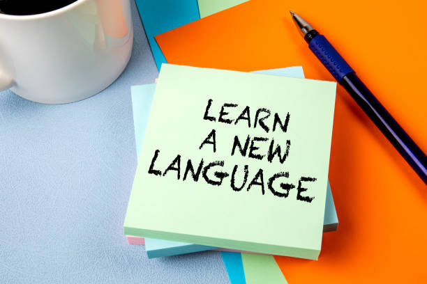 learn a new language. notepad with text on office table - engels taal stockfoto's en -beelden