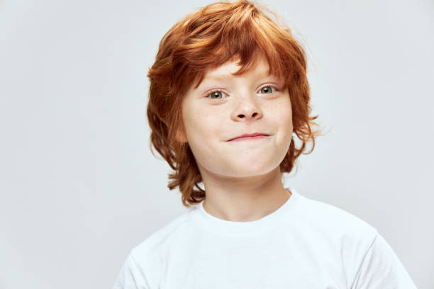 istock Smiling boy in white t-shirt studio cropped view gray background 2190104513