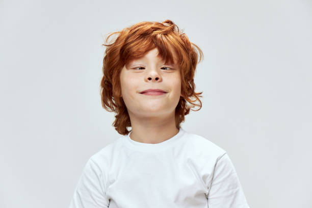 istock Grimacing red-haired boy squinting eyes cropped view and white t-shirt 2190108231