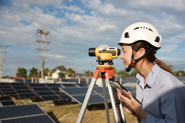 istock Female surveyor with leveling survey camera working at solar panel farm, green energy and  zero carbon, renewable energy 2190108622