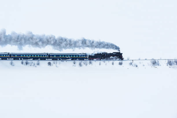 Retro steam train moves at winter morning.