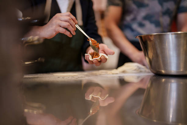 Filling Korean dumplings with rice noodles.
