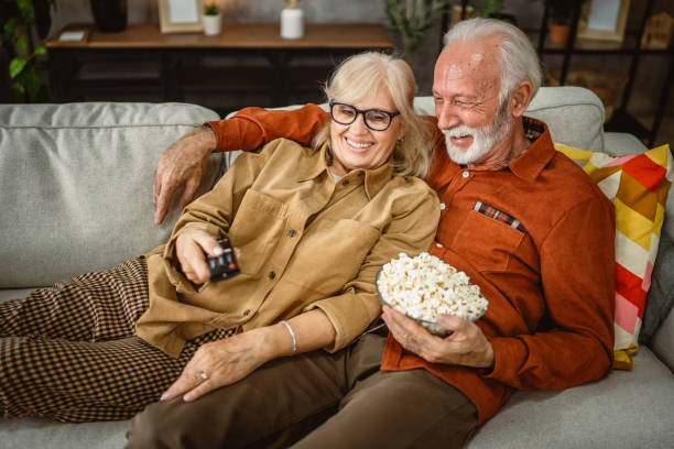 istock senior couple enjoy while watch television and sit on sofa 2190117813