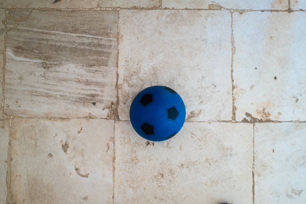 Blue plastic soccer ball on a tiled floor
