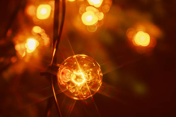Background - electric garland with incandescent bulbs, yellow warm light, retro style, star filter, atmospheric close-up
