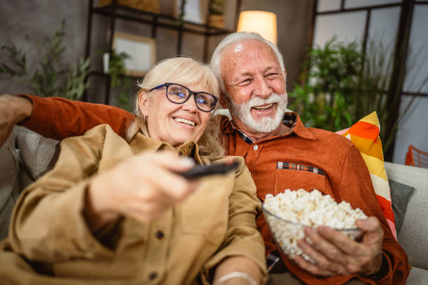 istock senior couple enjoy while watch television and sit on sofa 2190118105