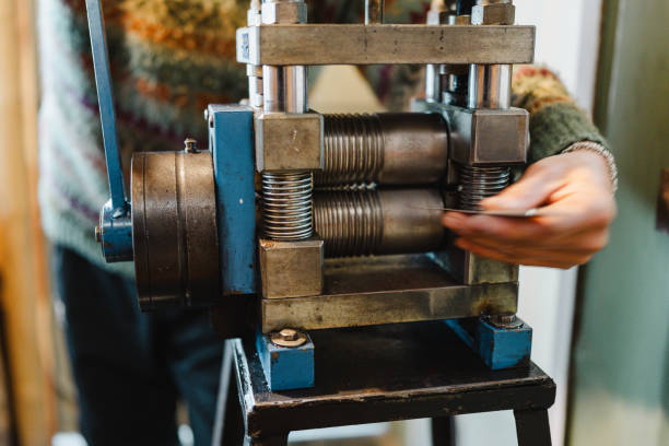 Close-up of a jeweler using a rolling mill, shaping metal for creating unique pieces of jewelry